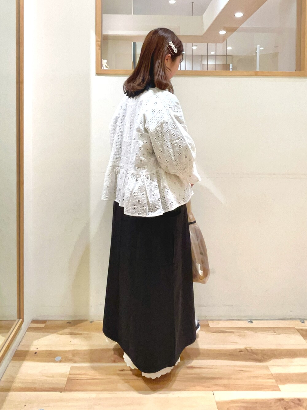 ベージュ系のハンドバッグ、ブラック系のサンダル、ブラック系のワンピースを着用したレディースの春コーディネートの4枚目の写真