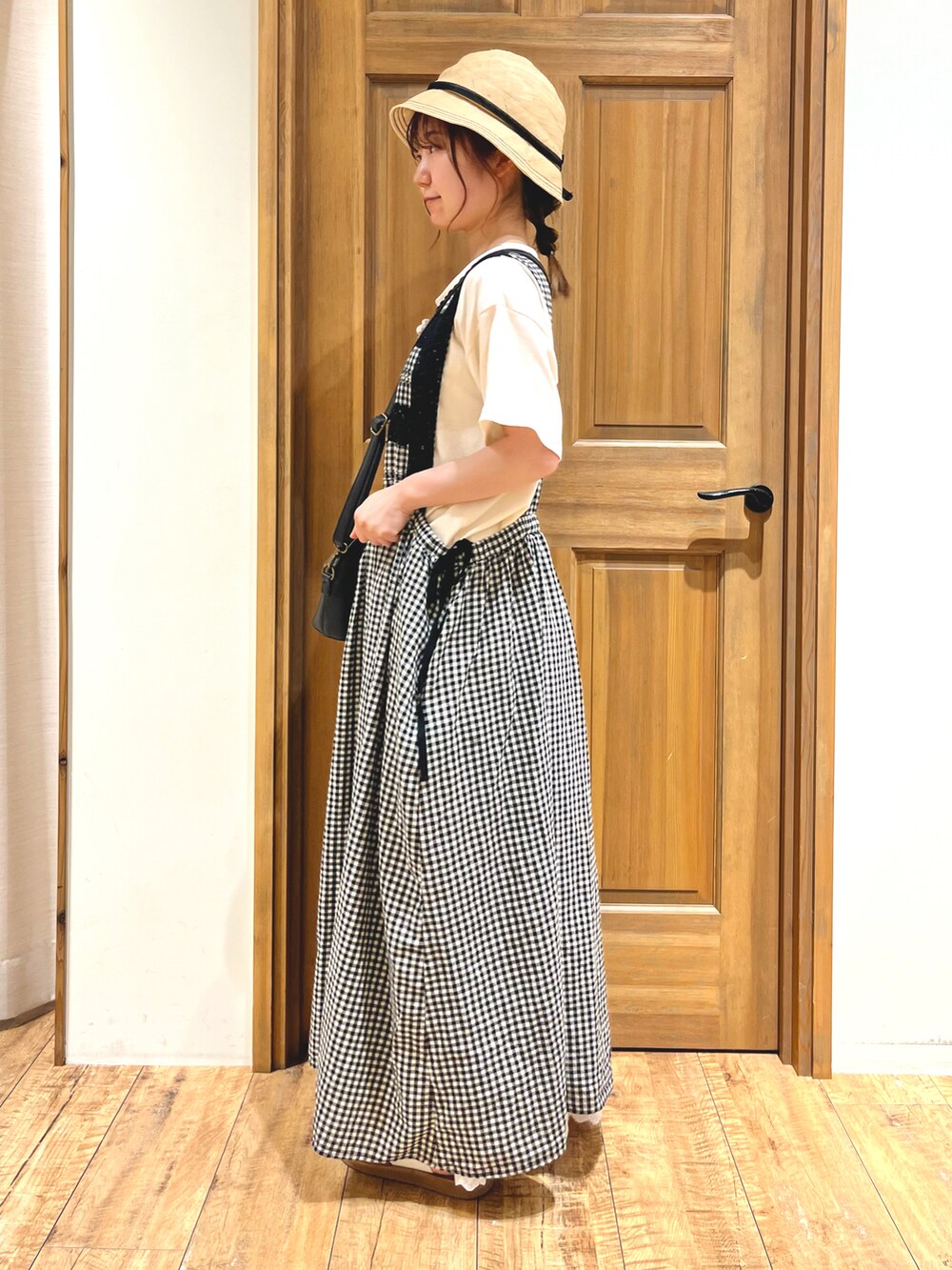 ブラック系のハンドバッグ、ブラック系のワンピース、ホワイト系のスカートを着用したレディースの夏コーディネートの2枚目の写真