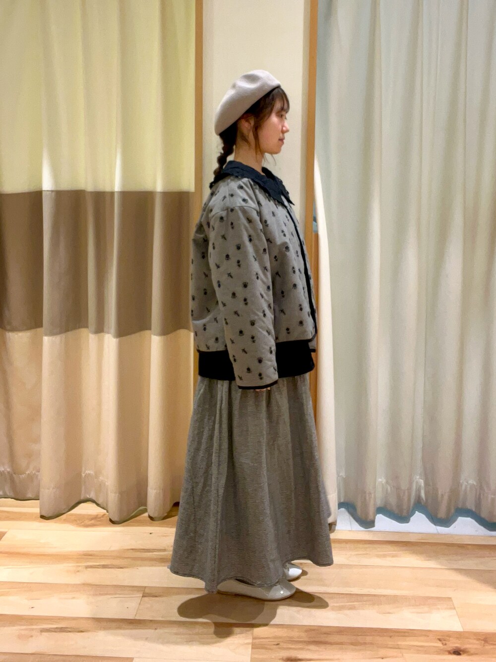 ブラック系のシャツ/ブラウス、グレー系のスカート、ホワイト系のパンプスを着用したレディースの冬コーディネートの2枚目の写真