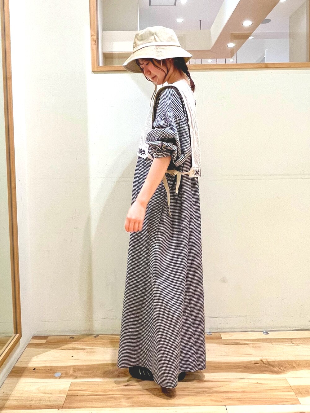 ベージュ系のベスト、ベージュ系のワンピース、ブラック系のサンダルを着用したレディースの春コーディネートの3枚目の写真