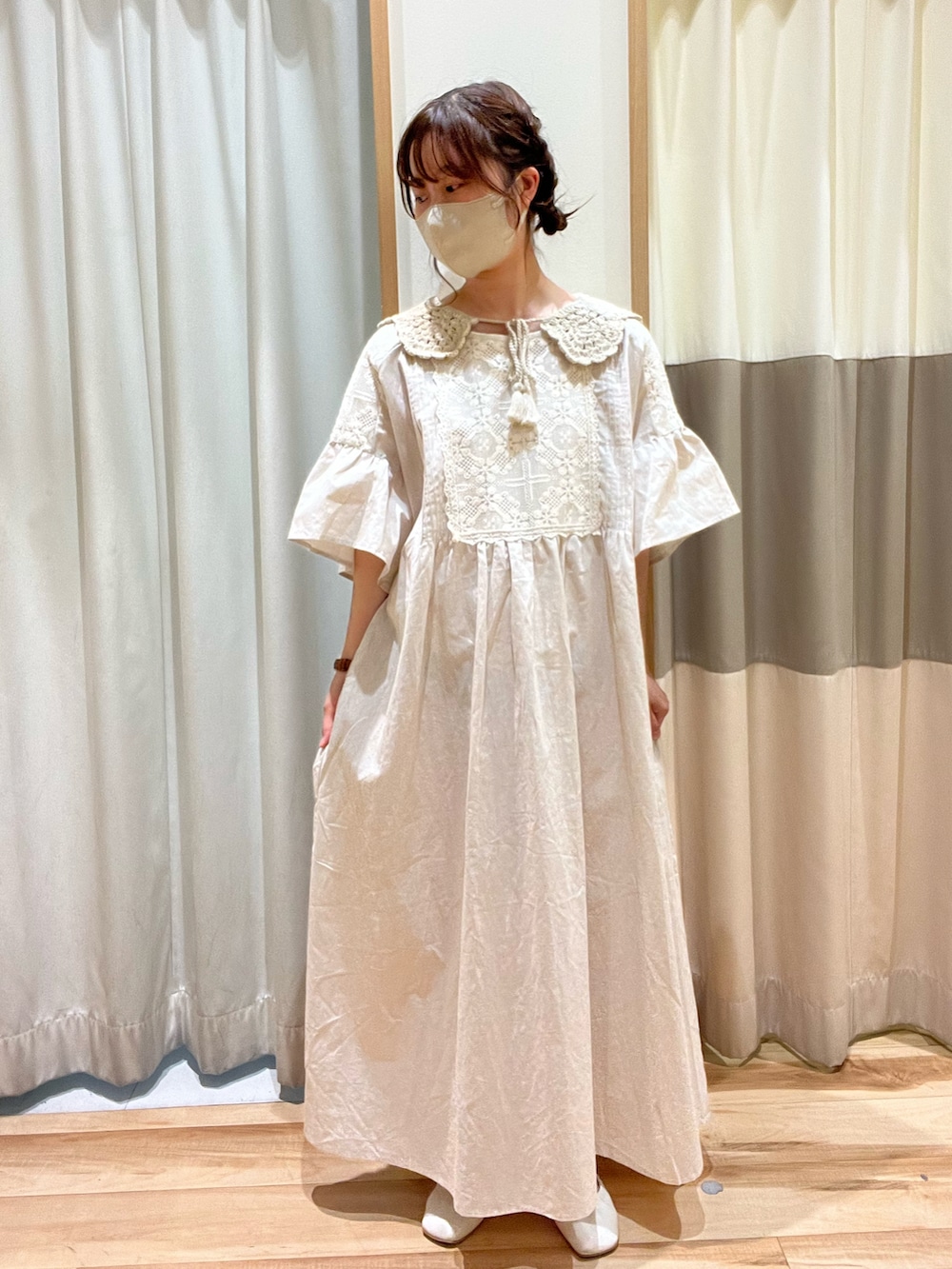ブラウン系のハンドバッグ、ホワイト系のワンピース、ベージュ系のストール/ショールを着用したレディースの春コーディネートの2枚目の写真