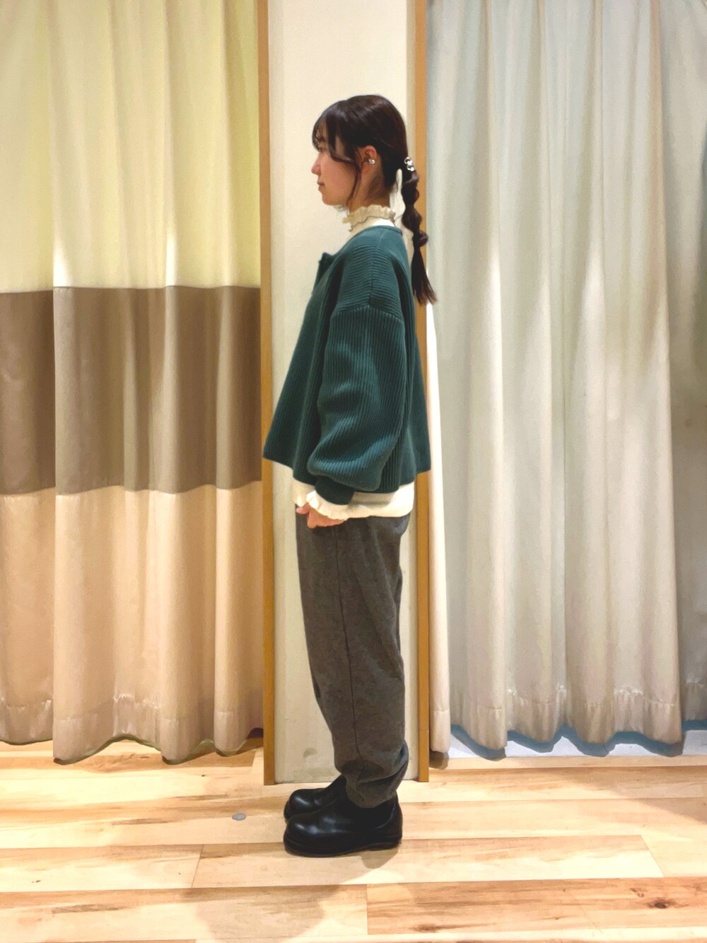 ホワイト系のニット/セーター、グレー系のその他パンツ、グリーン系のカーディガン/ボレロを着用したレディースの冬コーディネートの2枚目の写真