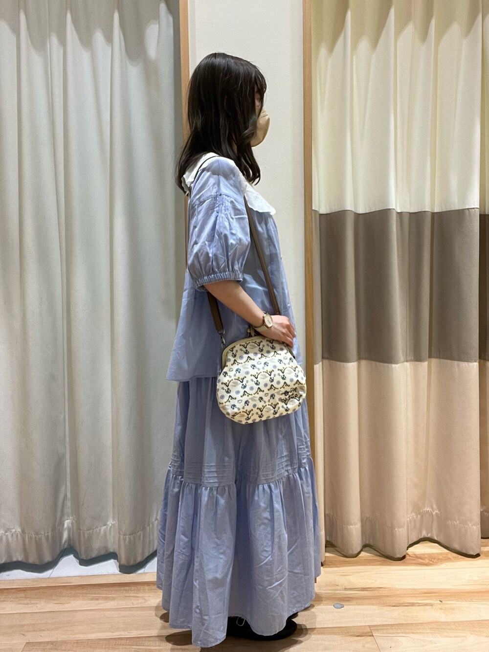 ブルー系のシャツ/ブラウス、ブルー系のスカート、ホワイト系のハンドバッグを着用したレディースの春コーディネートの2枚目の写真