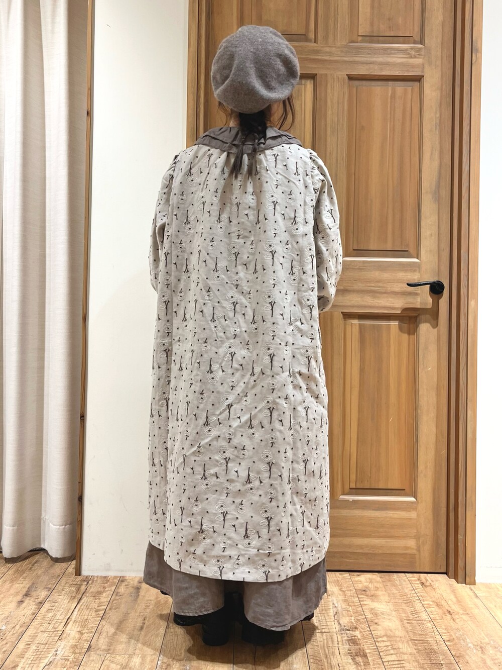 ブラウン系のバッグ、ブラック系のブーツ、グレー系のワンピースを着用したレディースの秋コーディネートの4枚目の写真