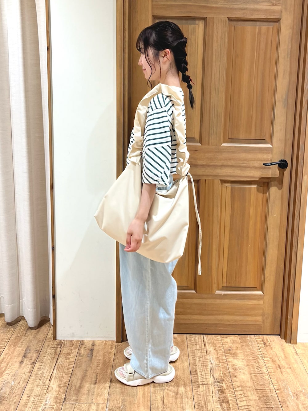 ブルー系のその他パンツ、ベージュ系のサンダル、ホワイト系のハンドバッグを着用したレディースの夏コーディネートの3枚目の写真