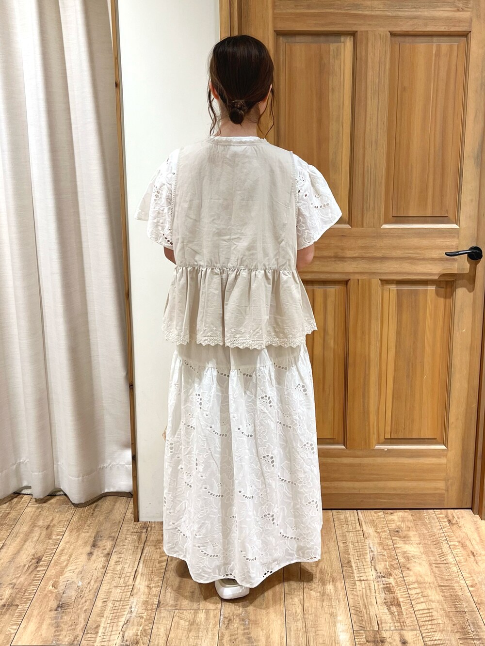 ベージュ系のサンダル、ベージュ系のハンドバッグ、ホワイト系のスカートを着用したレディースの夏コーディネートの4枚目の写真