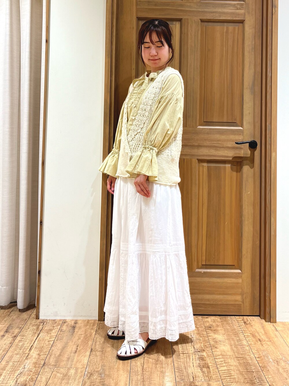 イエロー系のシャツ/ブラウス、ホワイト系のニット/セーター、ホワイト系のスカートを着用したレディースの夏コーディネートの3枚目の写真