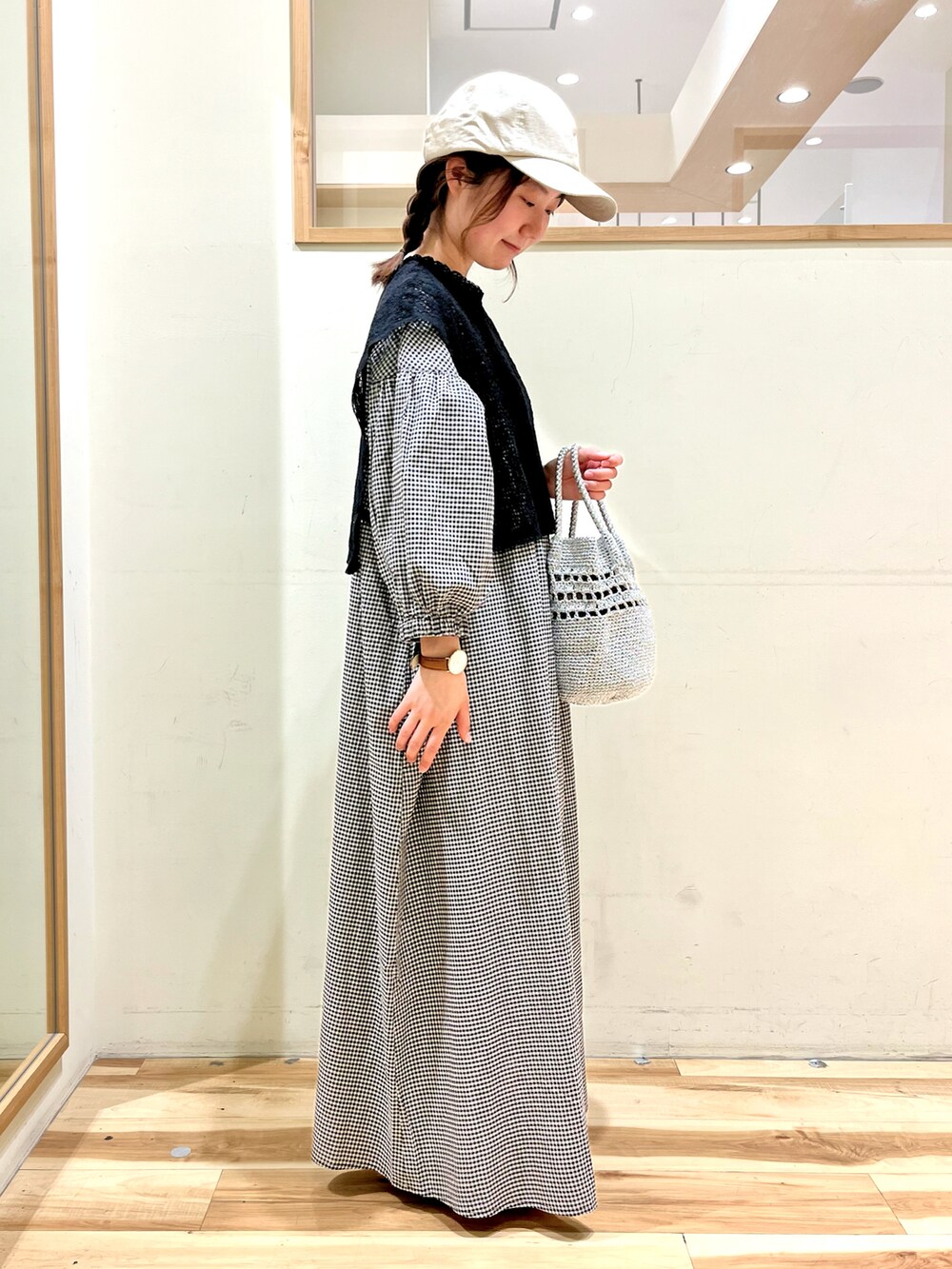 ベージュ系のワンピース、ブラック系のサンダル、シルバー系のハンドバッグを着用したレディースの春コーディネートの4枚目の写真