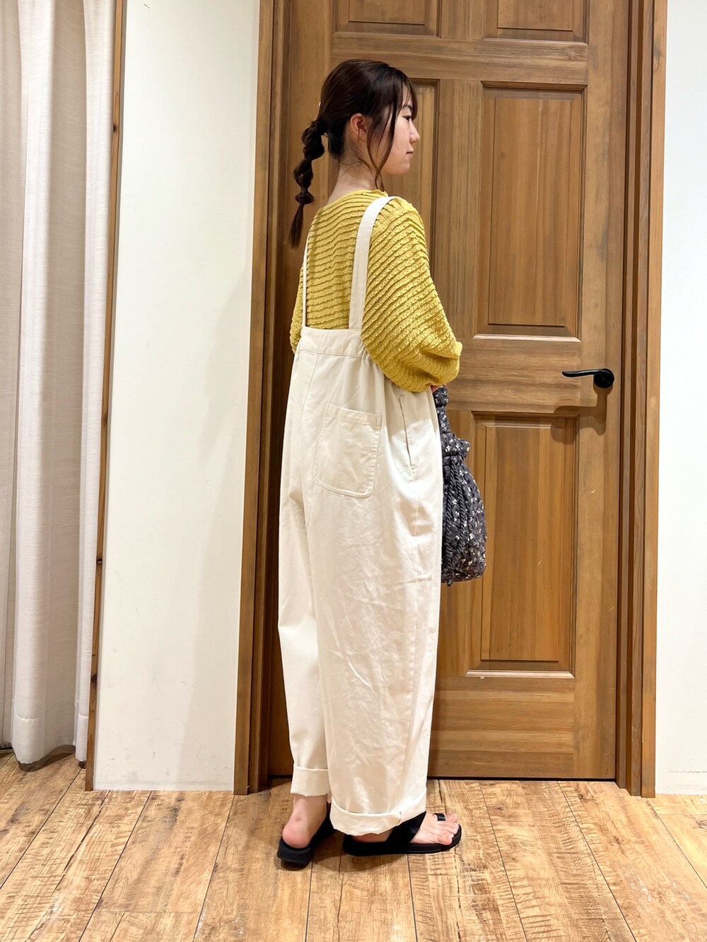 グレー系のハンドバッグ、ホワイト系のその他パンツ、イエロー系のカーディガン/ボレロを着用したレディースの夏コーディネートの4枚目の写真