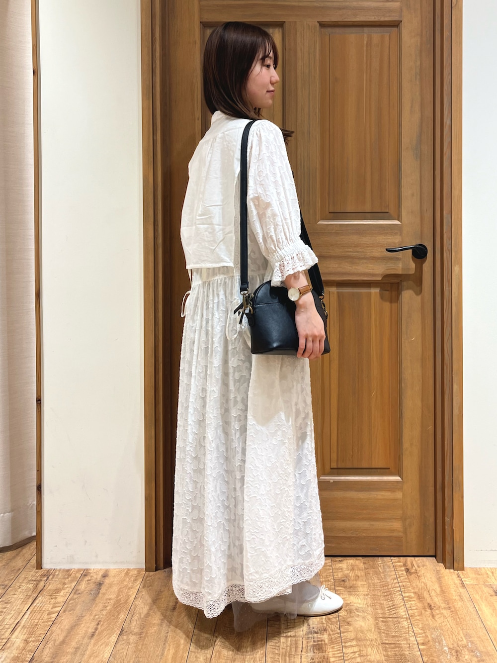 ブラック系のハンドバッグ、ブルー系のシャツ/ブラウス、ホワイト系のワンピースを着用したレディースの夏コーディネートの3枚目の写真