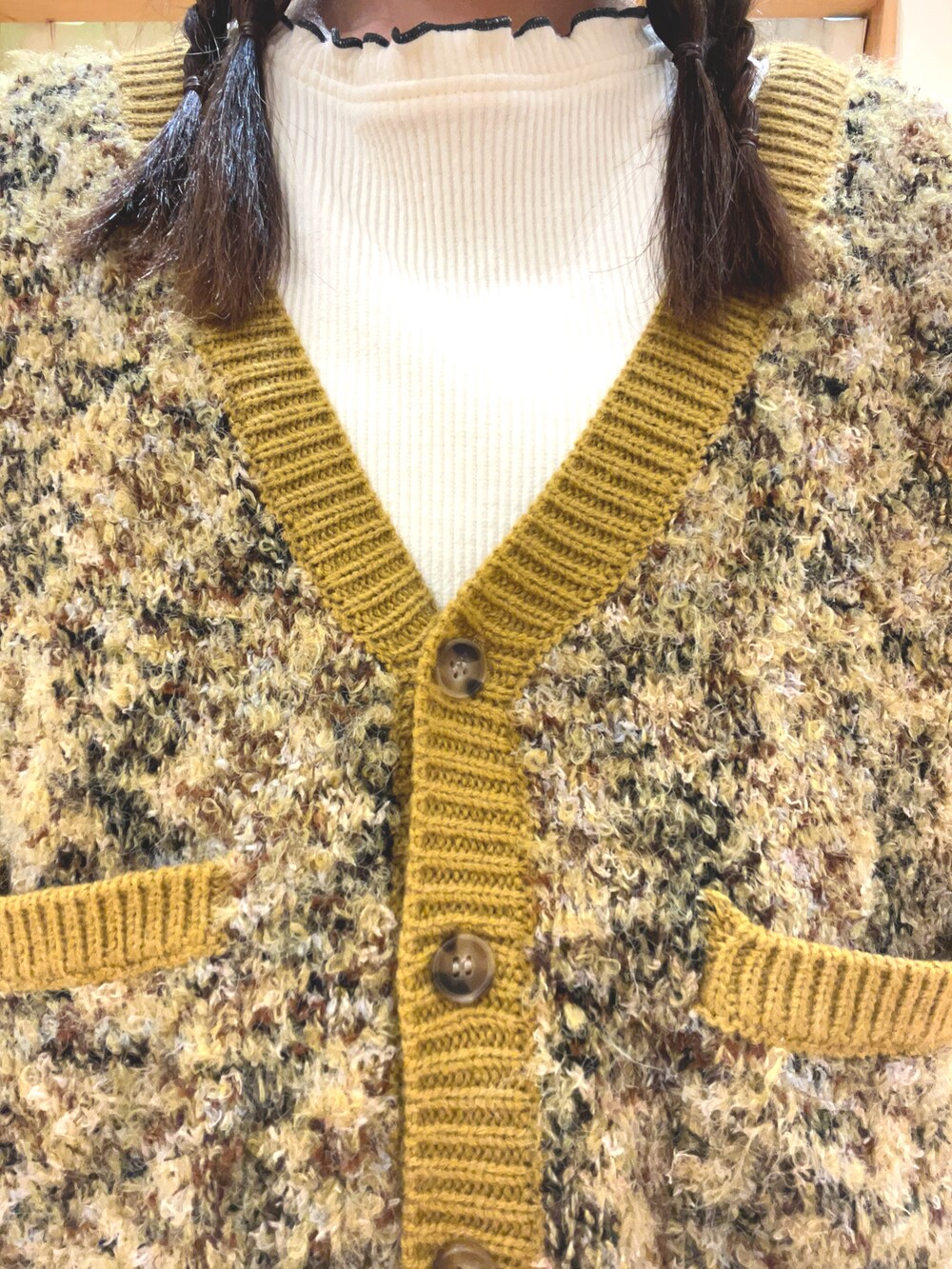 イエロー系のカーディガン/ボレロ、グリーン系のスカート、ホワイト系のTシャツ/カットソーを着用したレディースの冬コーディネートの5枚目の写真