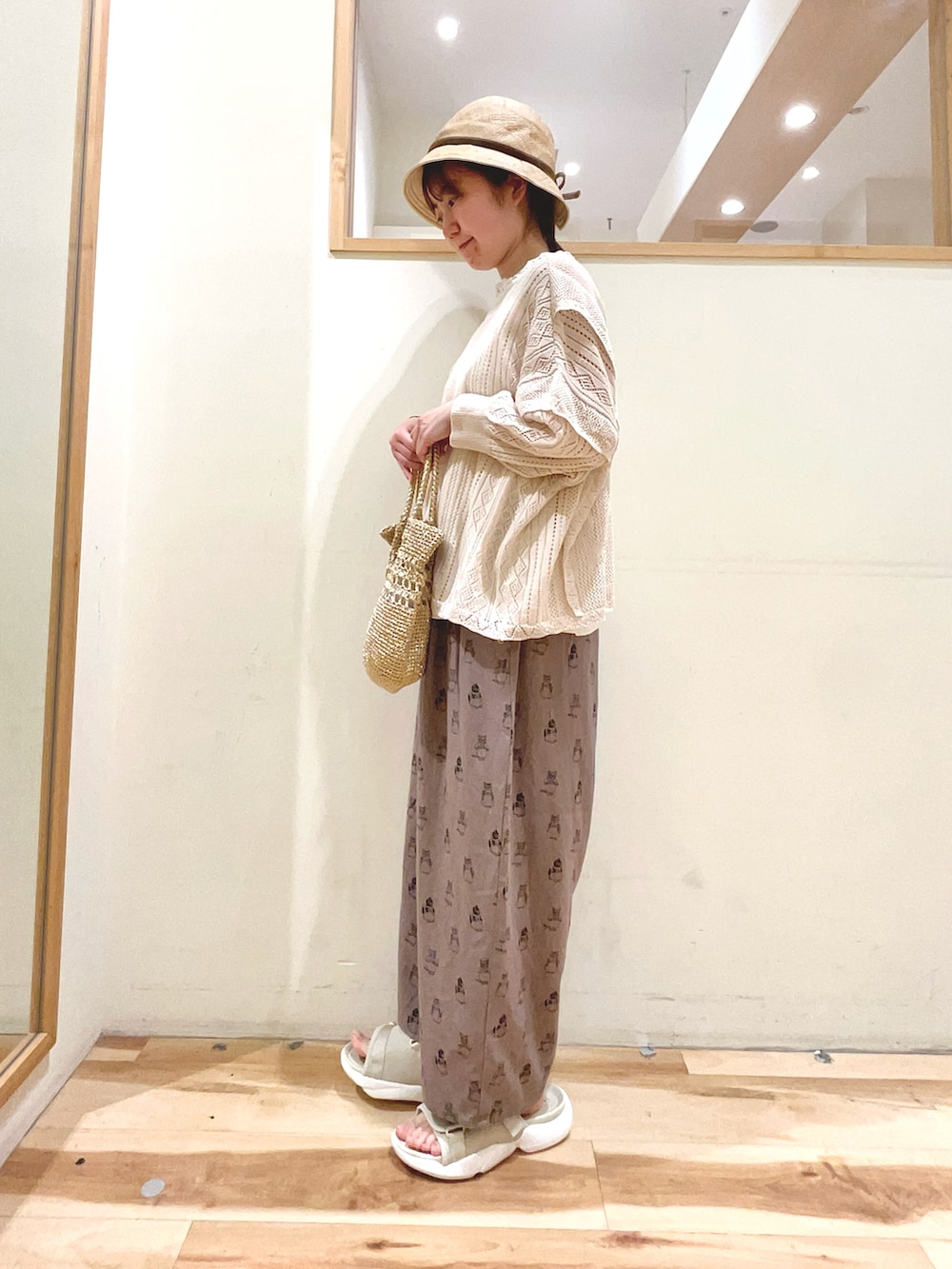 ホワイト系のTシャツ/カットソー、グレー系のその他パンツ、ベージュ系のサンダルを着用したレディースの春コーディネートの2枚目の写真