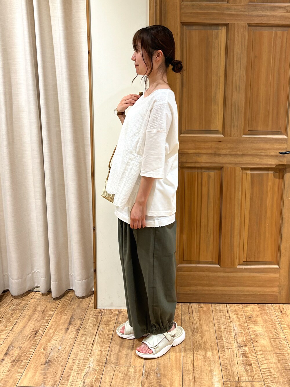 ホワイト系のハンドバッグ、ホワイト系のキャミソール、ホワイト系のTシャツ/カットソーを着用したレディースの夏コーディネートの2枚目の写真