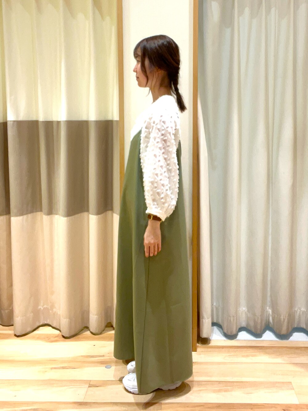 ブラック系のハンドバッグ、グリーン系のワンピース、ホワイト系のシャツ/ブラウスを着用したレディースの春コーディネートの2枚目の写真