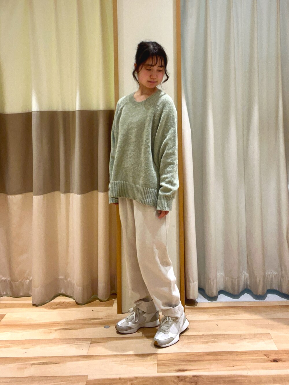 グリーン系のニット/セーター、ホワイト系のその他パンツを着用したレディースの冬コーディネートの2枚目の写真