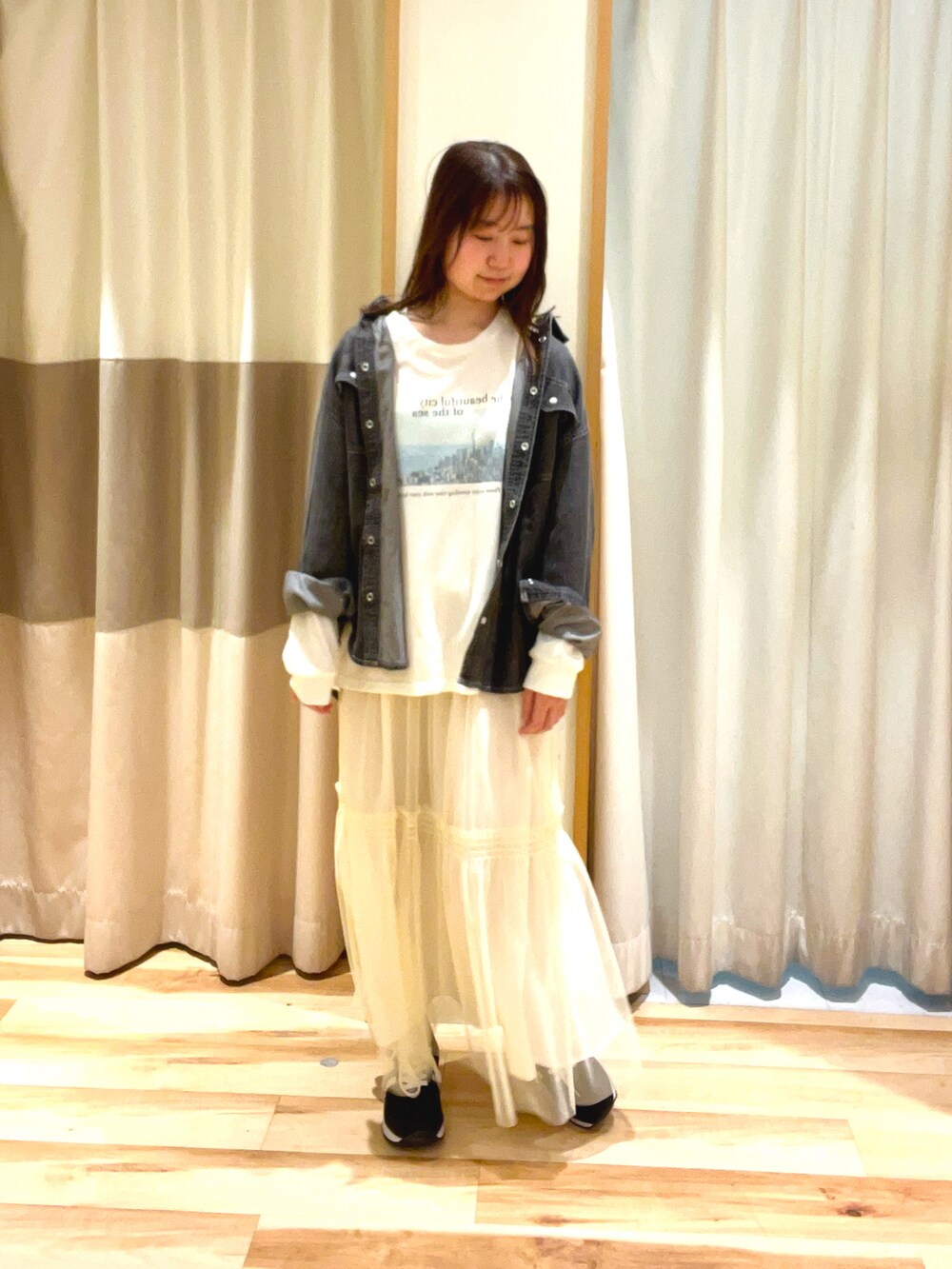 ホワイト系のTシャツ/カットソー、ホワイト系のスカート、グレー系のシャツ/ブラウスを着用したレディースの春コーディネートの2枚目の写真