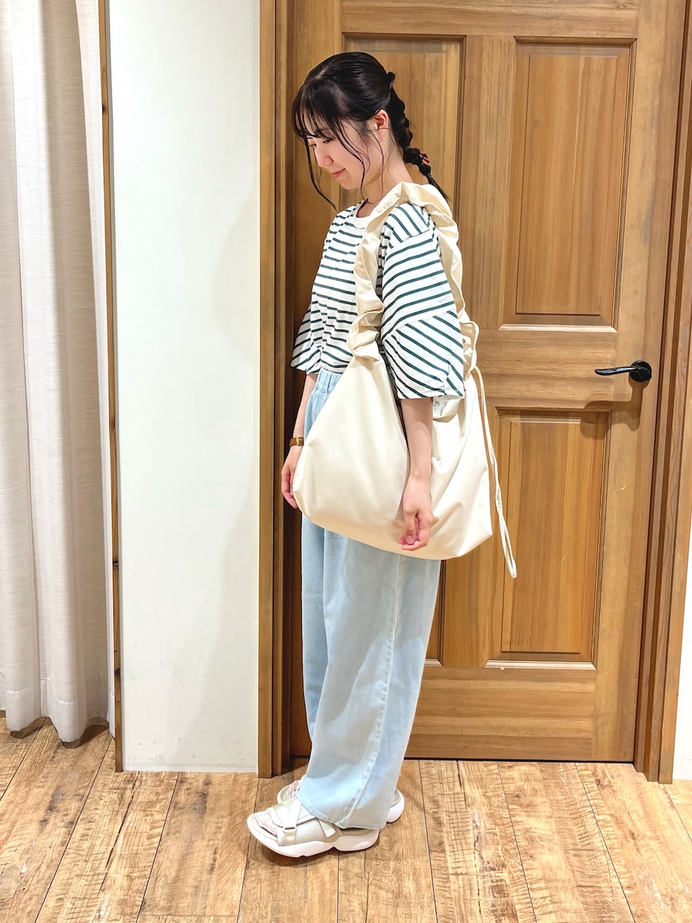 ブルー系のその他パンツ、ベージュ系のサンダル、ホワイト系のハンドバッグを着用したレディースの夏コーディネートの2枚目の写真