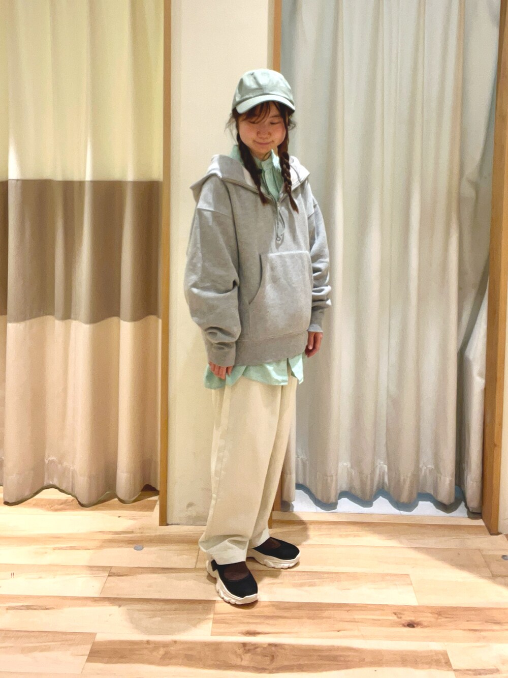 グリーン系のチュニック、グレー系のTシャツ/カットソー、ホワイト系のデニムパンツを着用したレディースの冬コーディネートの2枚目の写真