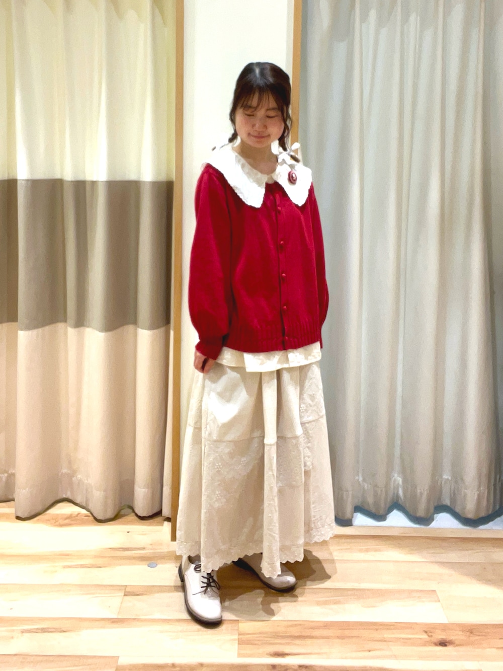 レッド系のカーディガン/ボレロ、ホワイト系のシャツ/ブラウス、ホワイト系のスカートを着用したレディースの春コーディネートの2枚目の写真