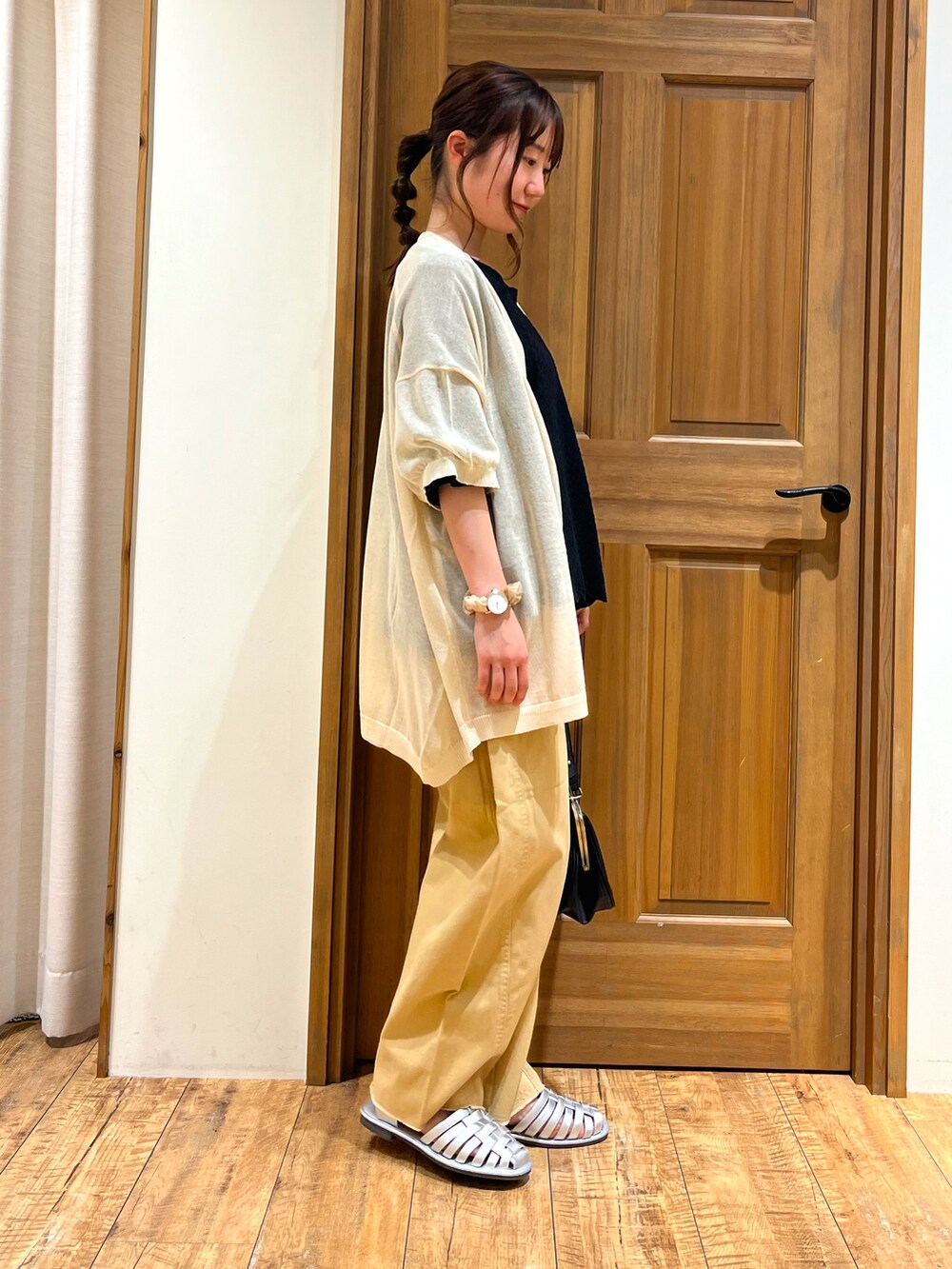 シルバー系のサンダル、ブラック系のハンドバッグ、ブラック系のTシャツ/カットソーを着用したレディースの夏コーディネートの2枚目の写真