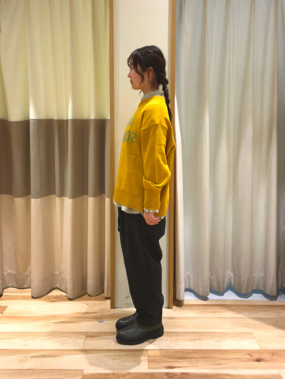 イエロー系のニット/セーター、グレー系のシャツ/ブラウス、グレー系のその他パンツを着用したレディースの冬コーディネートの3枚目の写真