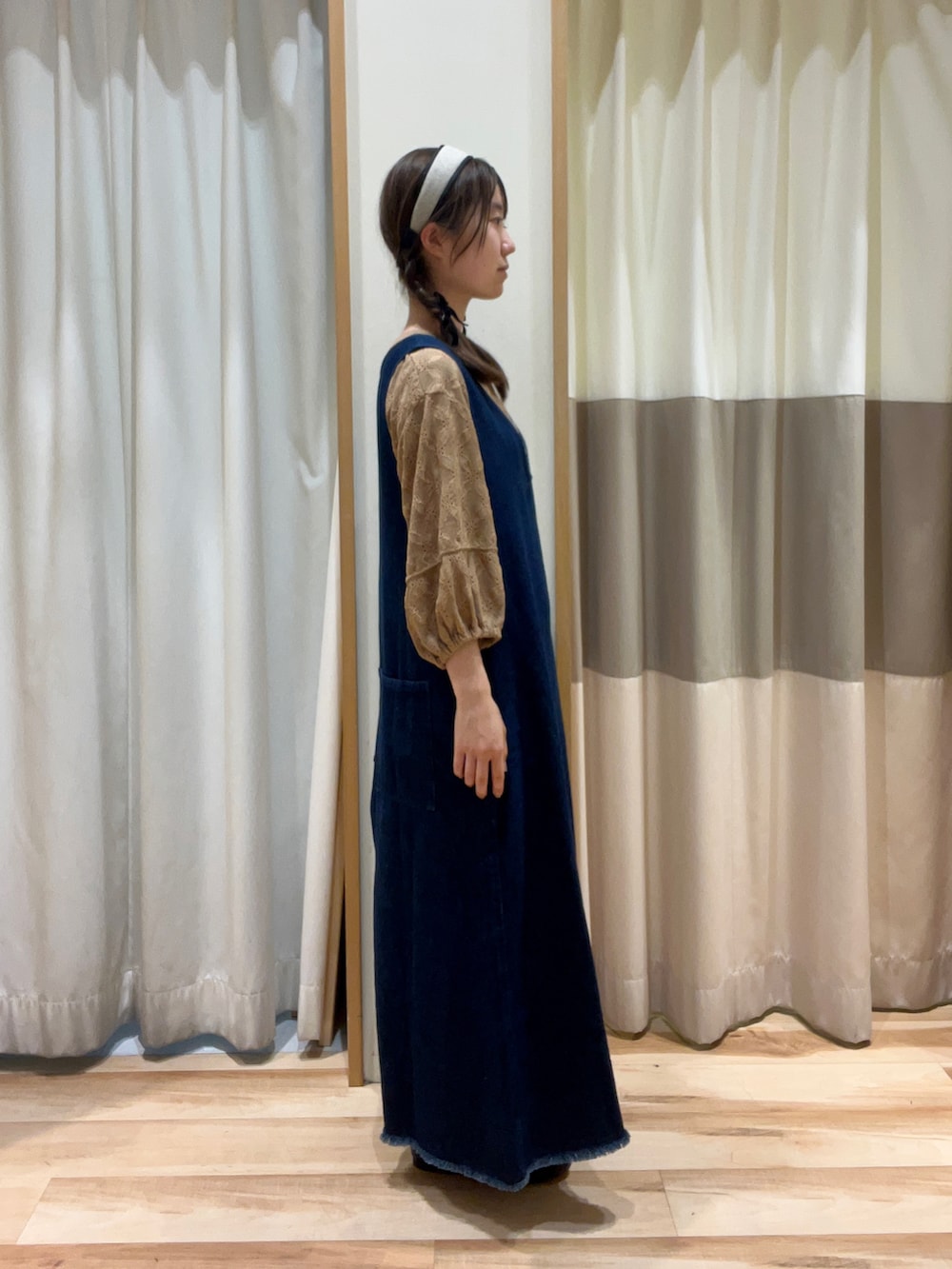 ベージュ系のTシャツ/カットソー、ブルー系のワンピース、ブラック系のハンドバッグを着用したレディースの秋コーディネートの2枚目の写真