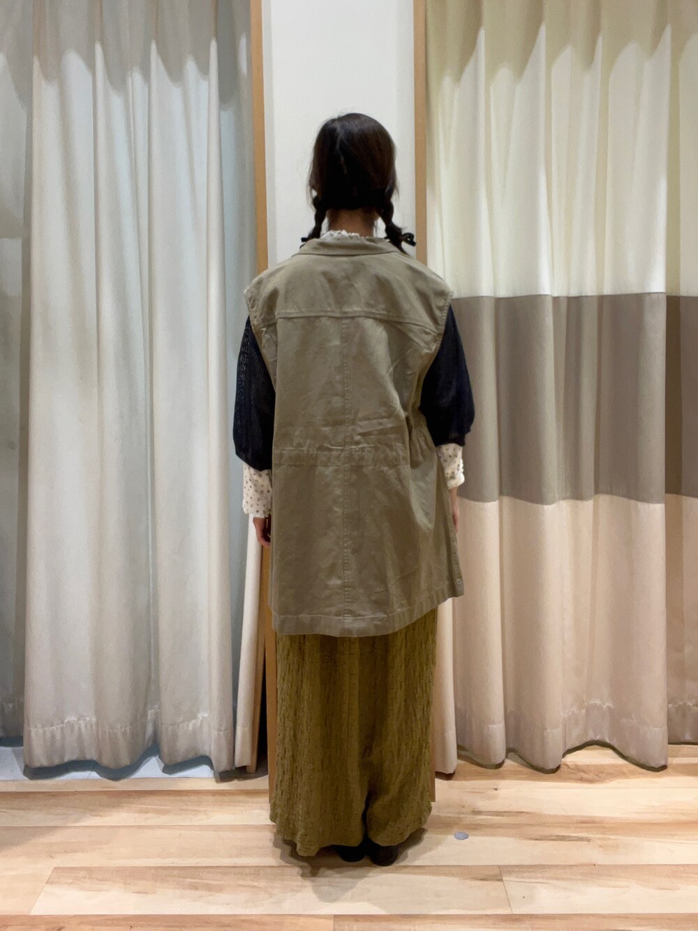 グレー系のニット/セーター、ベージュ系のワンピース、イエロー系のTシャツ/カットソーを着用したレディースの秋コーディネートの3枚目の写真