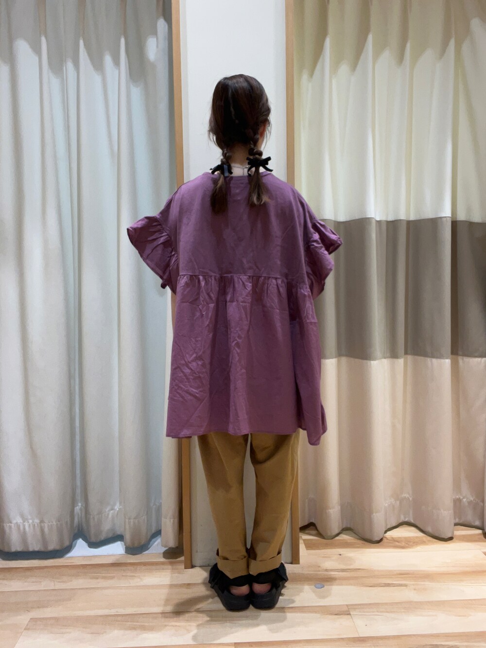 ベージュ系のその他パンツ、パープル系のチュニックを着用したレディースの夏コーディネートの3枚目の写真