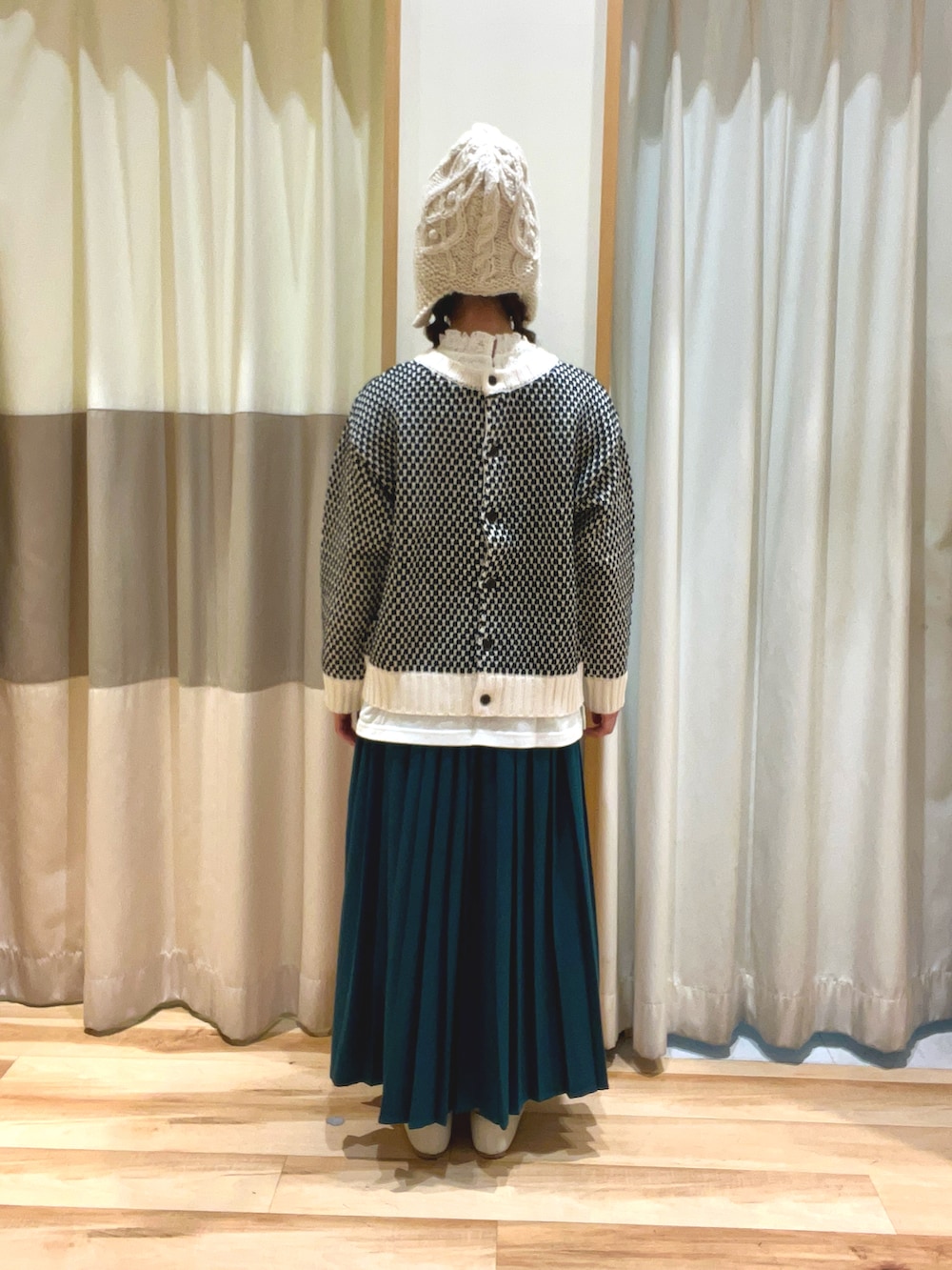 ブラック系のカーディガン/ボレロ、ホワイト系のTシャツ/カットソー、グリーン系のスカートを着用したレディースの秋コーディネートの3枚目の写真