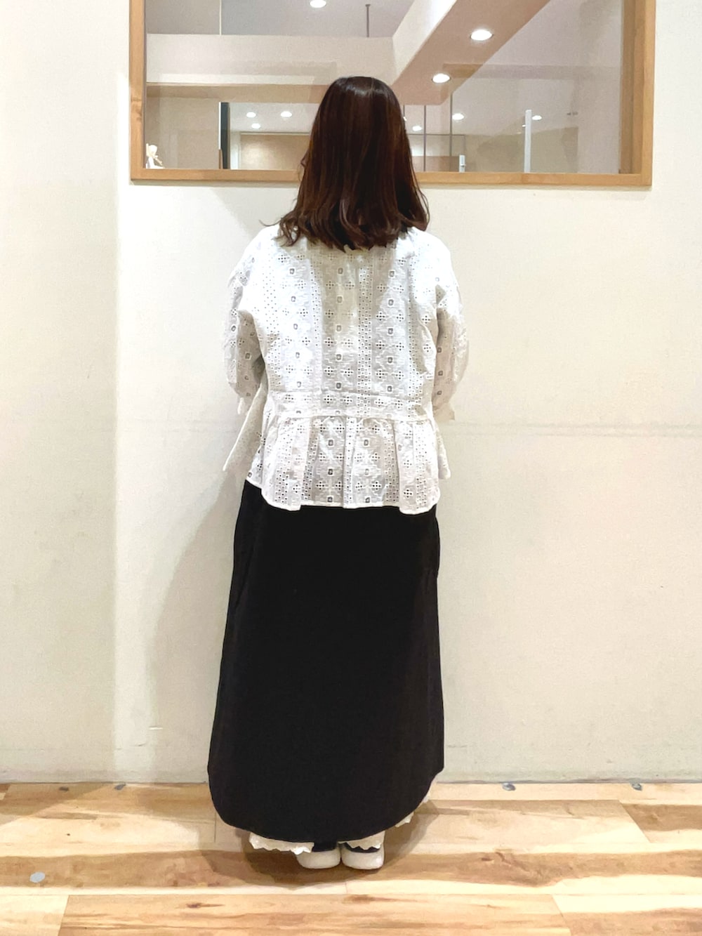 ベージュ系のハンドバッグ、ブラック系のサンダル、ブラック系のワンピースを着用したレディースの春コーディネートの3枚目の写真