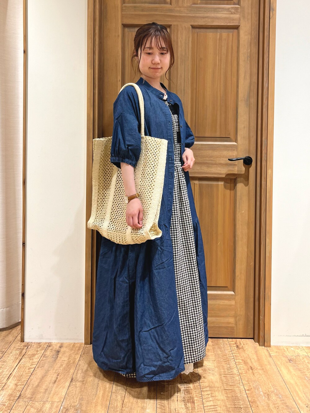 ホワイト系のハンドバッグ、ブルー系のワンピース、ブラック系のワンピースを着用したレディースの夏コーディネートの2枚目の写真