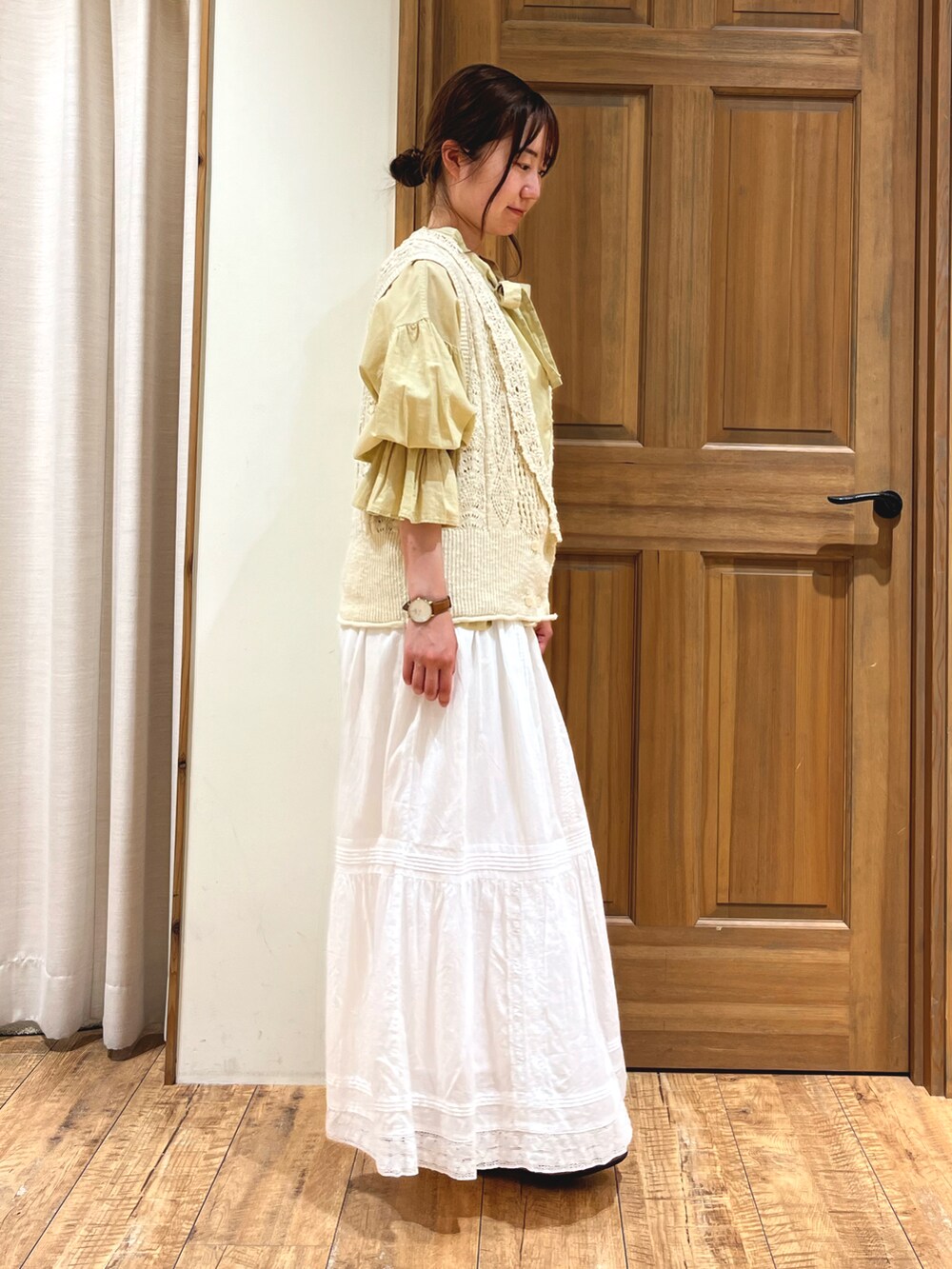 イエロー系のシャツ/ブラウス、ホワイト系のニット/セーター、ホワイト系のスカートを着用したレディースの夏コーディネートの4枚目の写真
