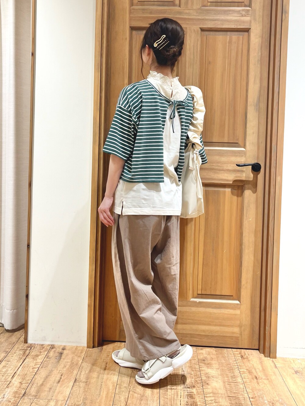 ベージュ系のサンダル、ホワイト系のハンドバッグ、ブラウン系のその他パンツを着用したレディースの夏コーディネートの4枚目の写真