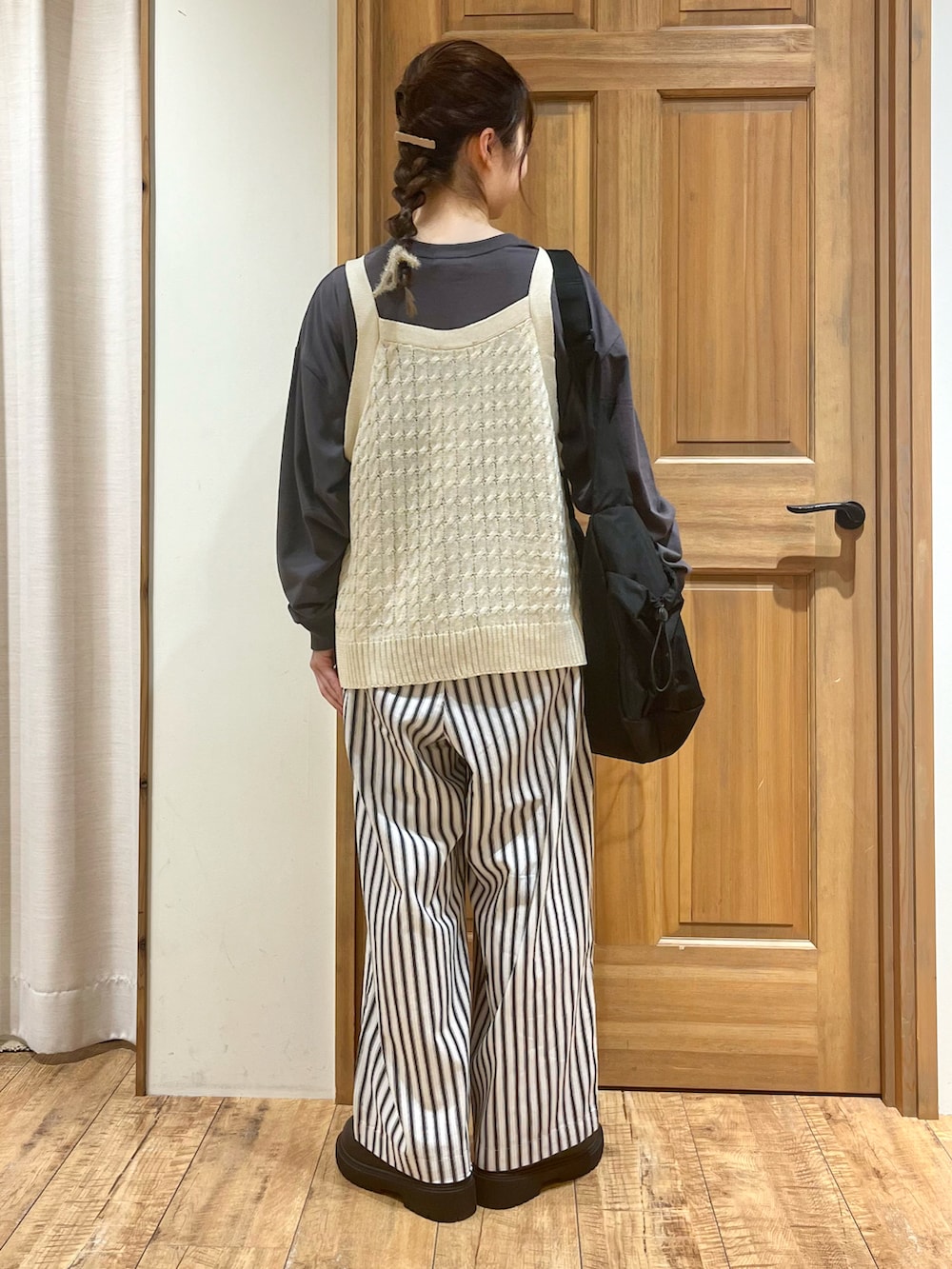 ブラック系のブーツ、ホワイト系のその他パンツ、ホワイト系のベストを着用したレディースの秋コーディネートの4枚目の写真