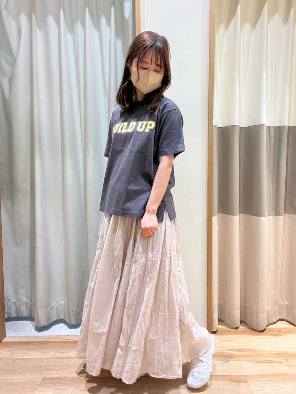 グレー系のTシャツ/カットソー、ホワイト系のハンドバッグ、グレー系のスカートを着用したレディースの春コーディネートの2枚目の写真