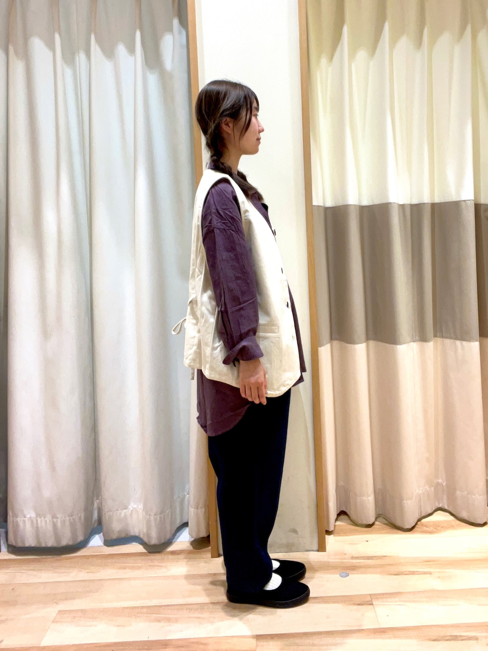 パープル系のチュニック、ブルー系のデニムパンツ、ブラック系のスニーカーを着用したレディースの秋コーディネートの2枚目の写真