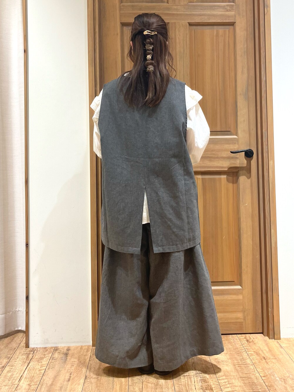 ブラック系のブーツ、ホワイト系のシャツ/ブラウス、ブラック系のベストを着用したレディースの秋コーディネートの4枚目の写真