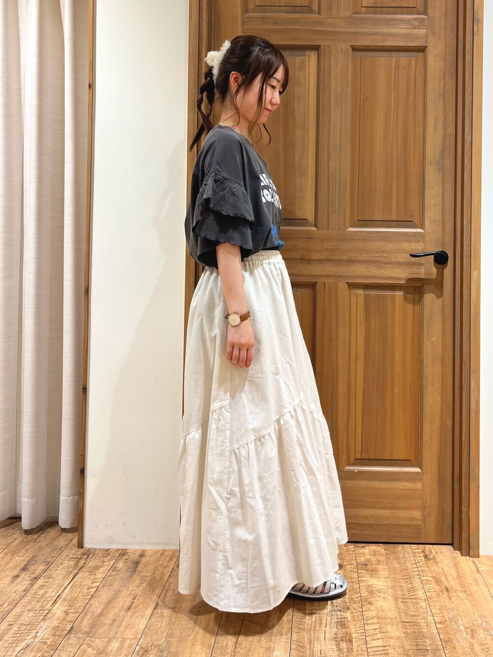 シルバー系のサンダル、ホワイト系のスカート、グレー系のTシャツ/カットソーを着用したレディースの夏コーディネートの2枚目の写真