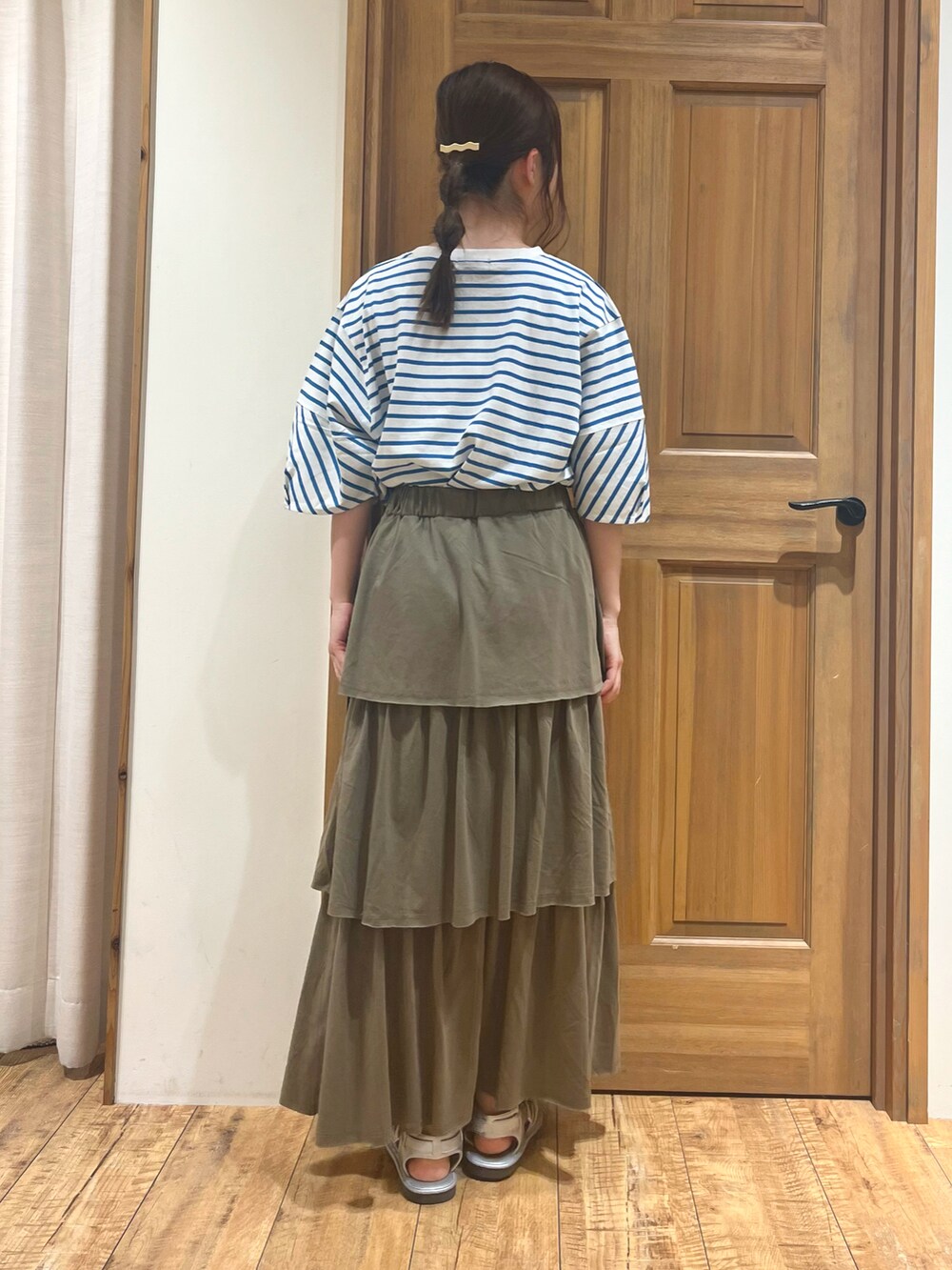 シルバー系のサンダル、ブルー系のTシャツ/カットソー、グリーン系のスカートを着用したレディースの夏コーディネートの4枚目の写真