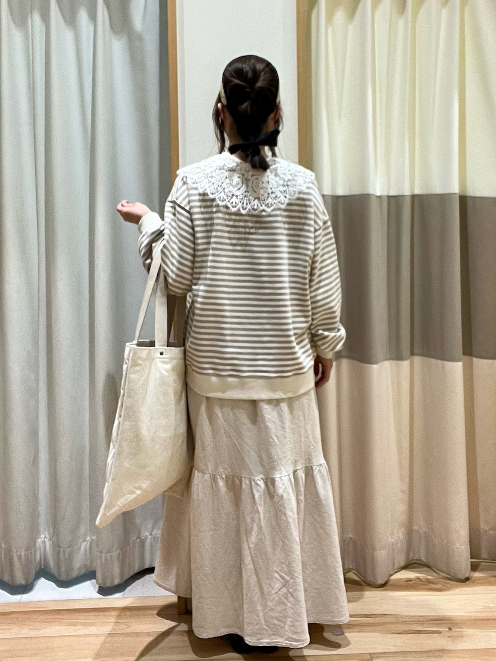 ホワイト系のニット/セーター、ベージュ系のハンドバッグ、ホワイト系のスカートを着用したレディースの冬コーディネートの3枚目の写真