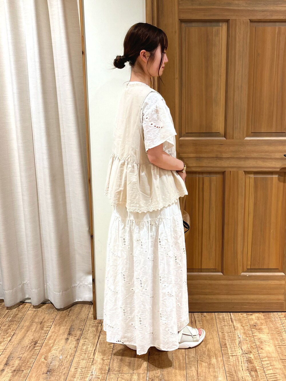 ベージュ系のサンダル、ベージュ系のハンドバッグ、ホワイト系のスカートを着用したレディースの夏コーディネートの5枚目の写真