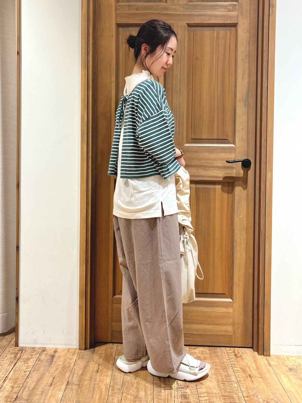 ベージュ系のサンダル、ホワイト系のハンドバッグ、ブラウン系のその他パンツを着用したレディースの夏コーディネートの3枚目の写真