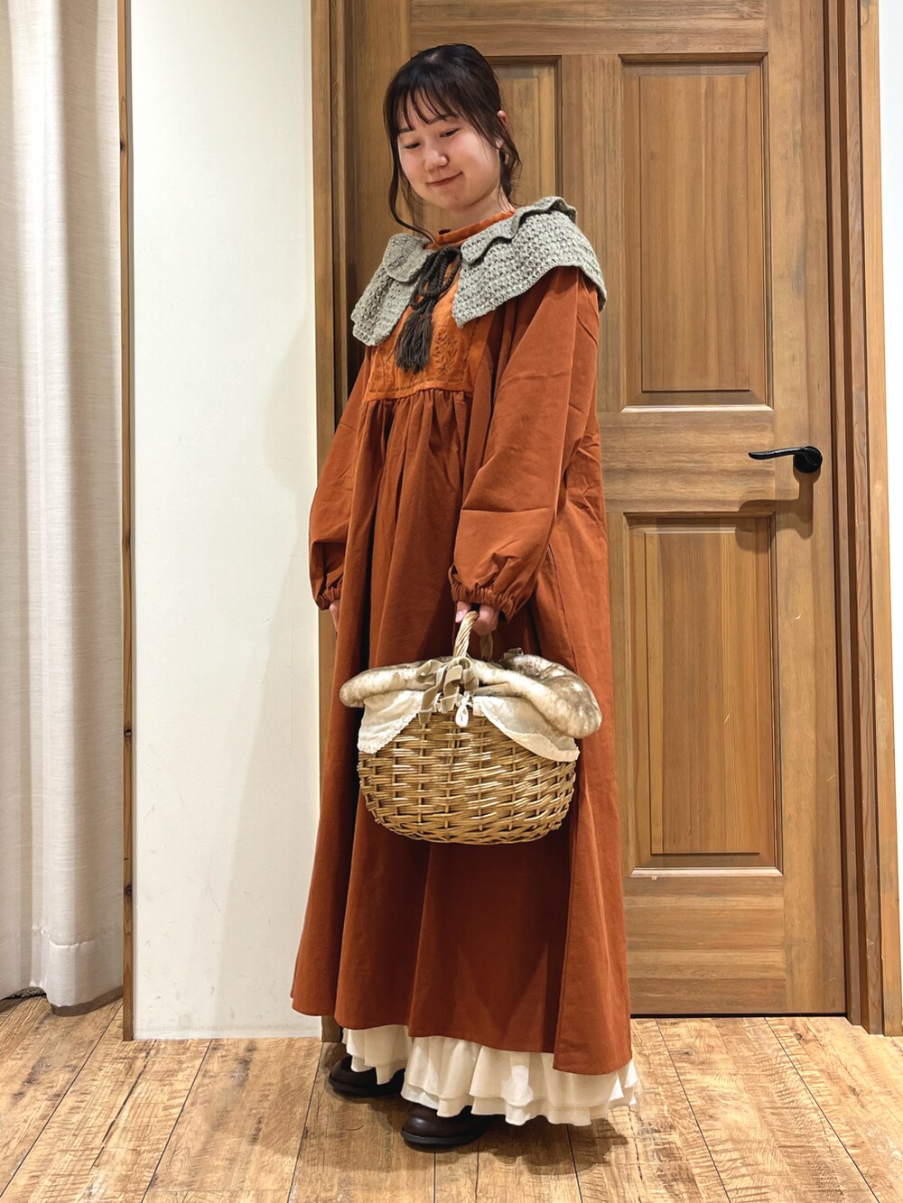 ベージュ系のバッグ、オレンジ系のワンピース、ホワイト系のその他パンツを着用したレディースの秋コーディネートの2枚目の写真