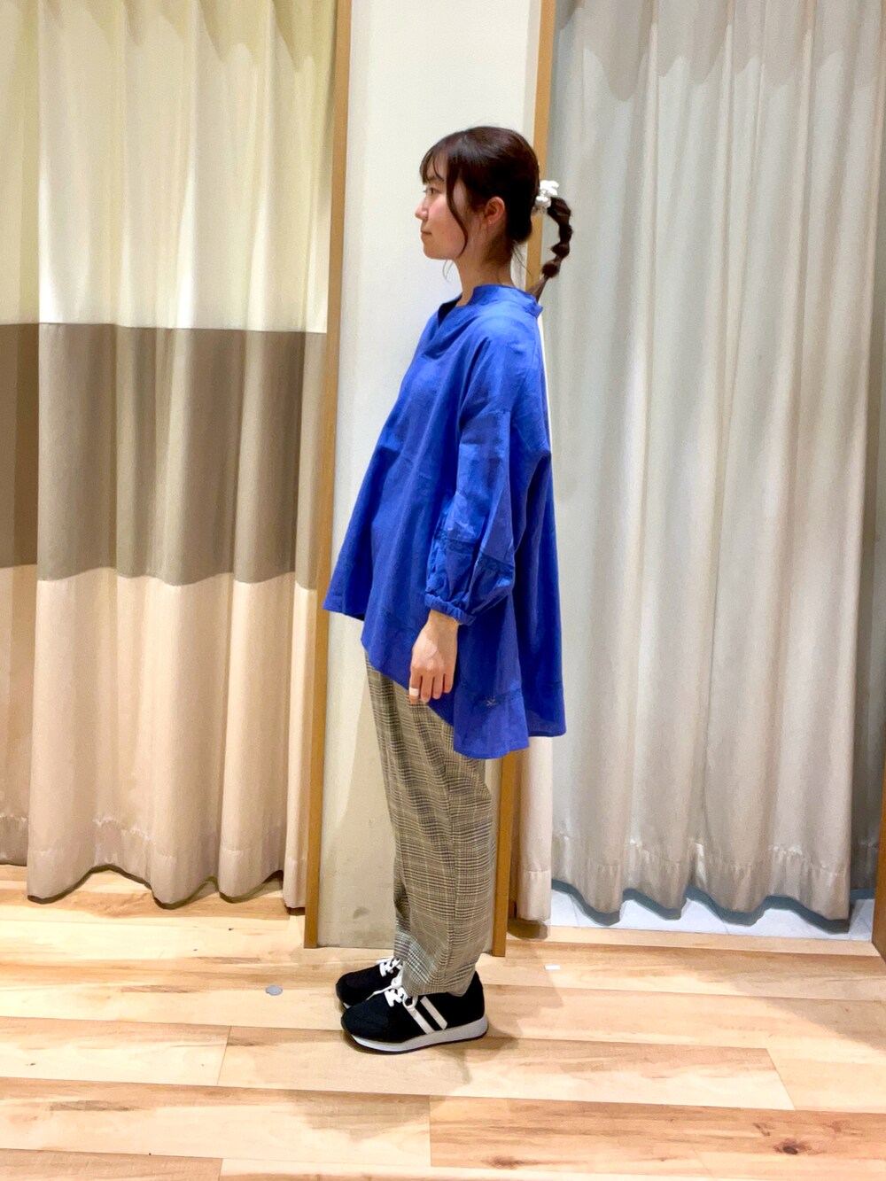 ブラック系のハンドバッグ、ブルー系のシャツ/ブラウス、グリーン系のスラックスを着用したレディースの春コーディネートの3枚目の写真