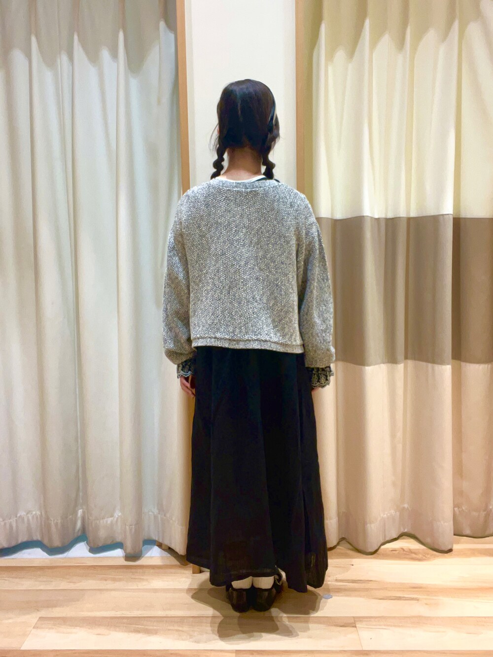 ブラック系のワンピース、ブラック系のノーカラージャケット、ベージュ系のネックレスを着用したレディースの秋コーディネートの3枚目の写真