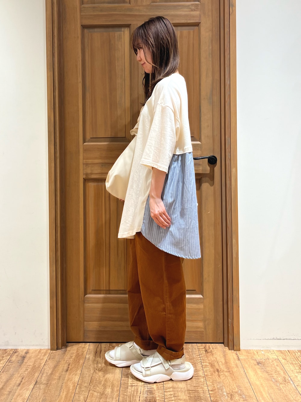 ホワイト系のハンドバッグ、ブラウン系のその他パンツ、ベージュ系のサンダルを着用したレディースの夏コーディネートの3枚目の写真