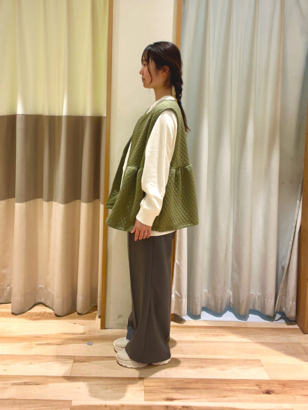 ホワイト系のTシャツ/カットソー、グリーン系のベスト、ブラック系のハンドバッグを着用したレディースの冬コーディネートの4枚目の写真