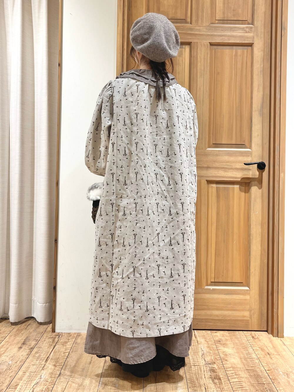 ブラウン系のバッグ、ブラック系のブーツ、グレー系のワンピースを着用したレディースの秋コーディネートの3枚目の写真