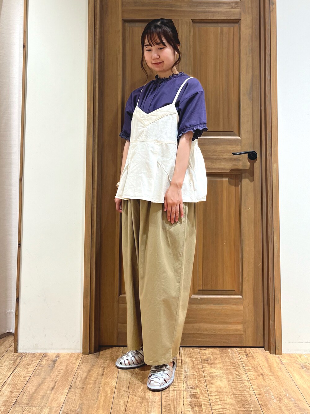 シルバー系のサンダル、ベージュ系のその他パンツ、ホワイト系のベストを着用したレディースの夏コーディネートの2枚目の写真