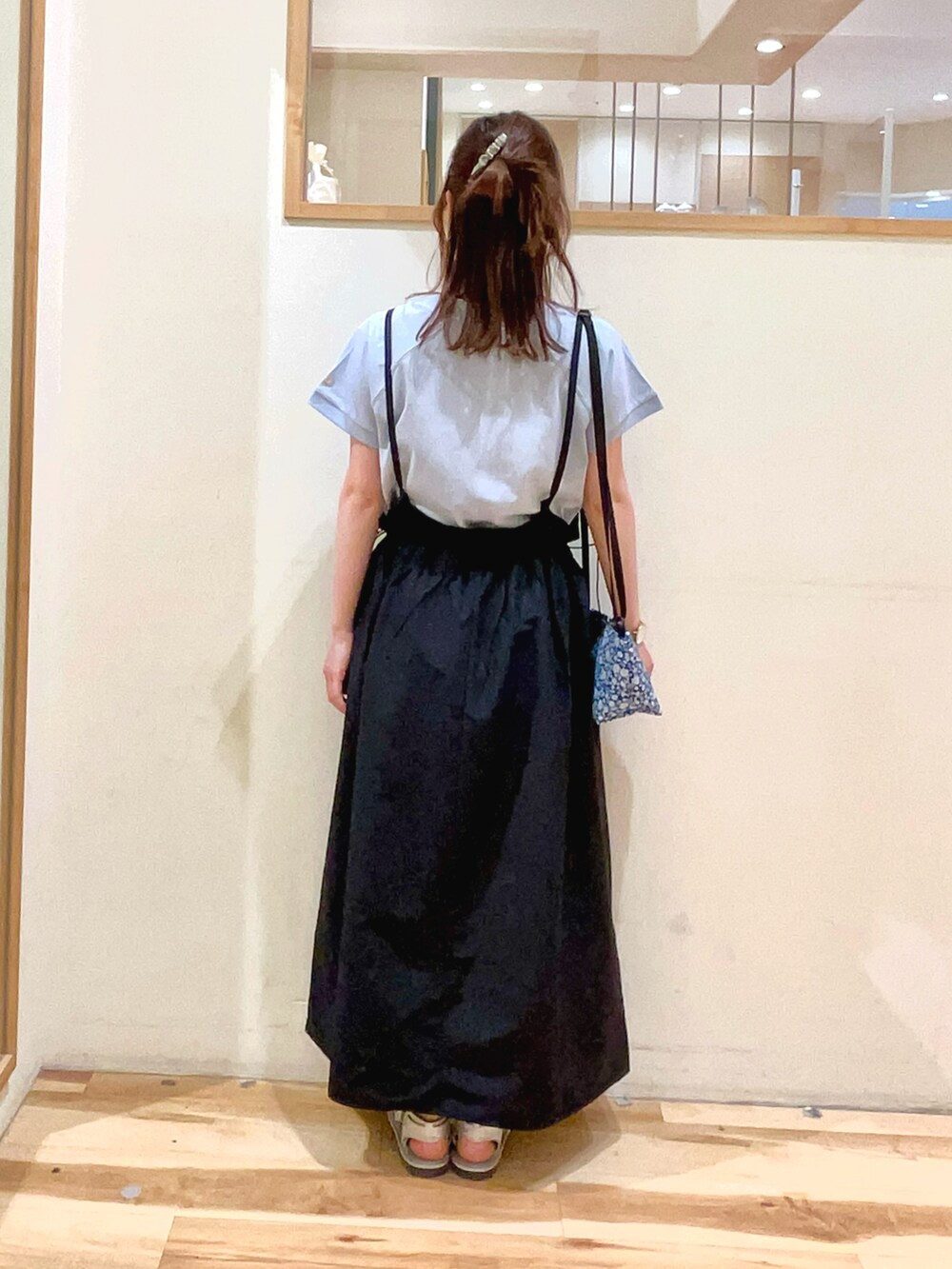 ブルー系のハンドバッグ、ブラック系のワンピース、ブルー系のTシャツ/カットソーを着用したレディースの春コーディネートの5枚目の写真